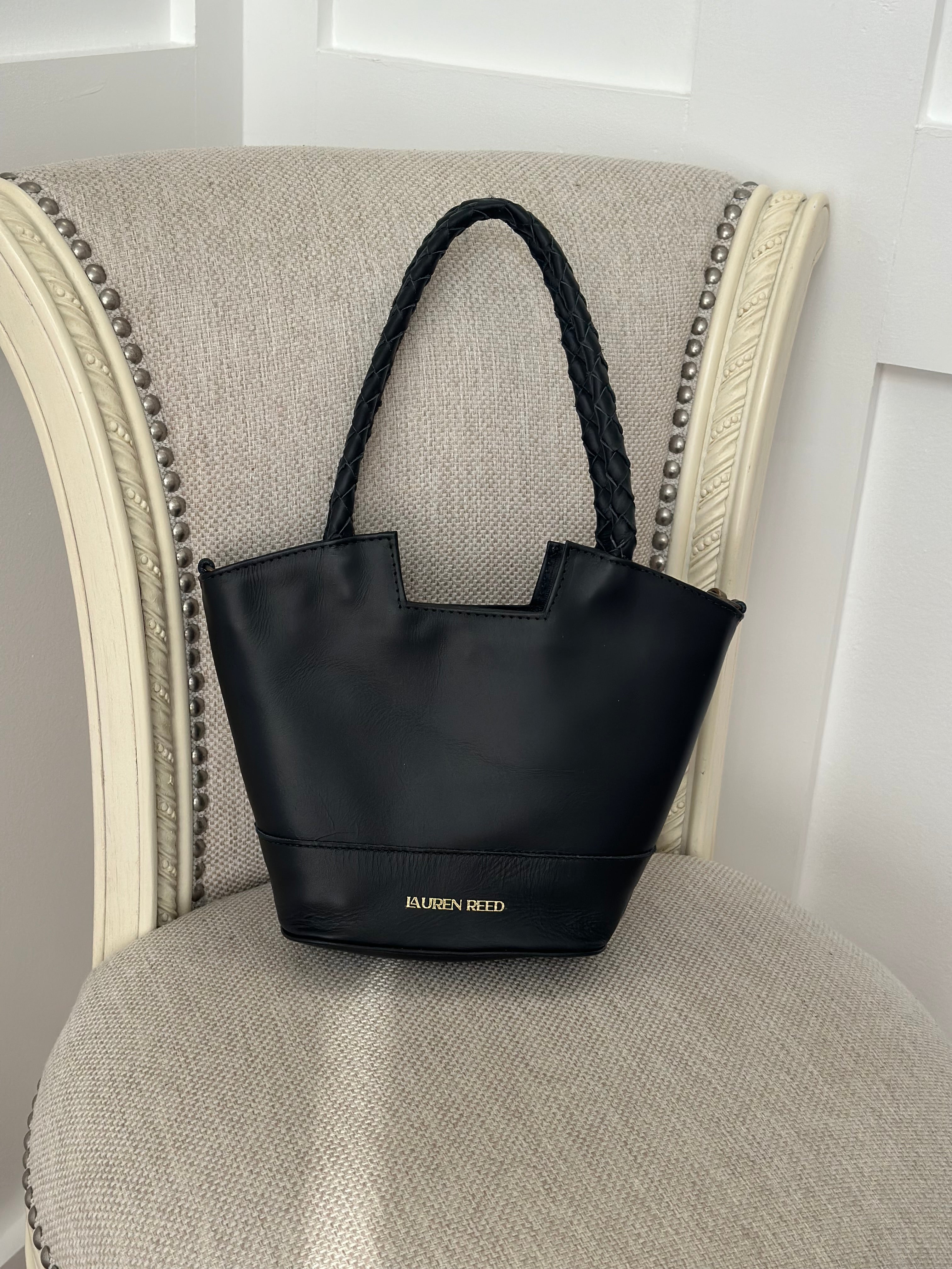 Black handbag with brand name on a textured surface