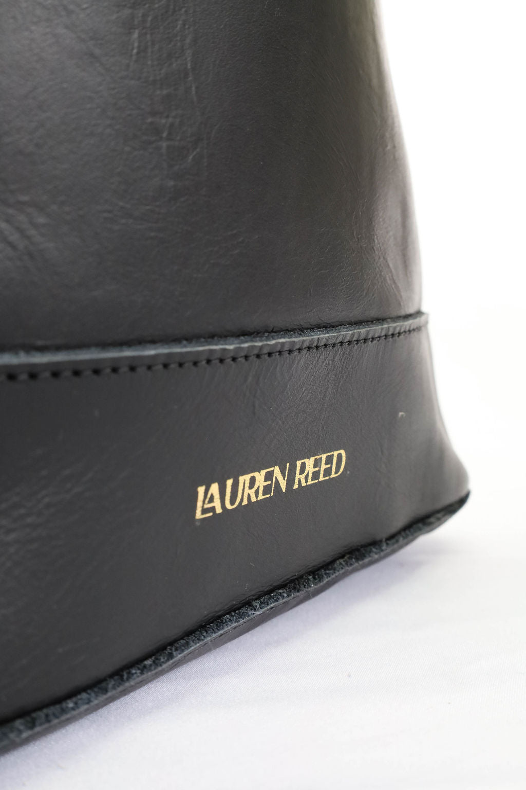 Black leather bag with 'Lauren Reed' branding on a white background