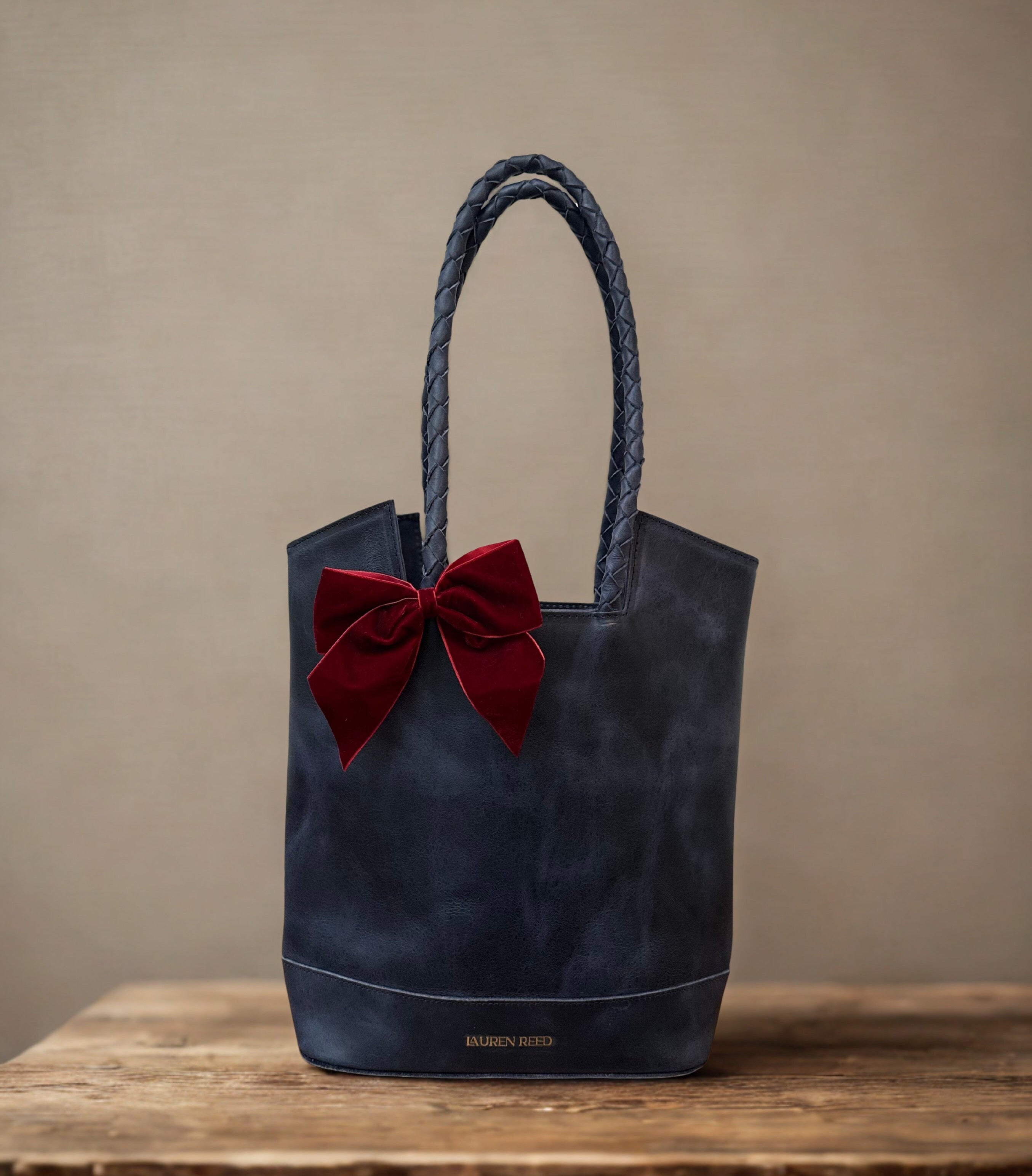 Leather Bag with Bow on wooden table
