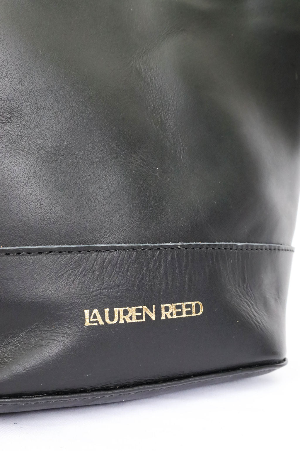 Black leather bag with 'Lauren Reed' logo on a white background