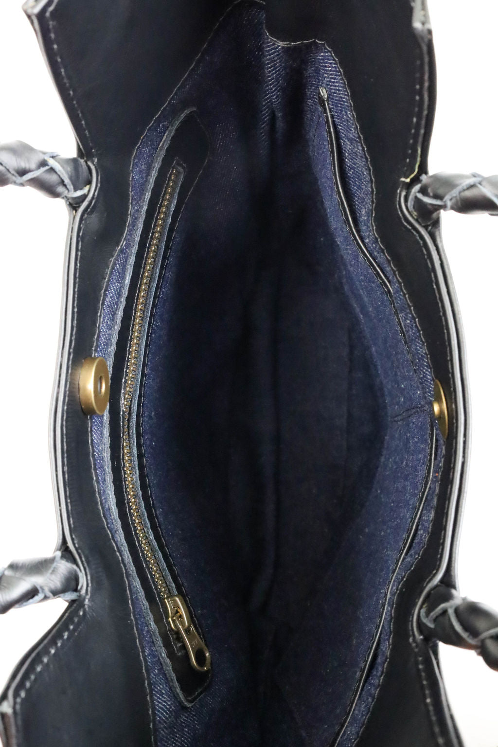 Close-up of a dark blue leather bag with zipper