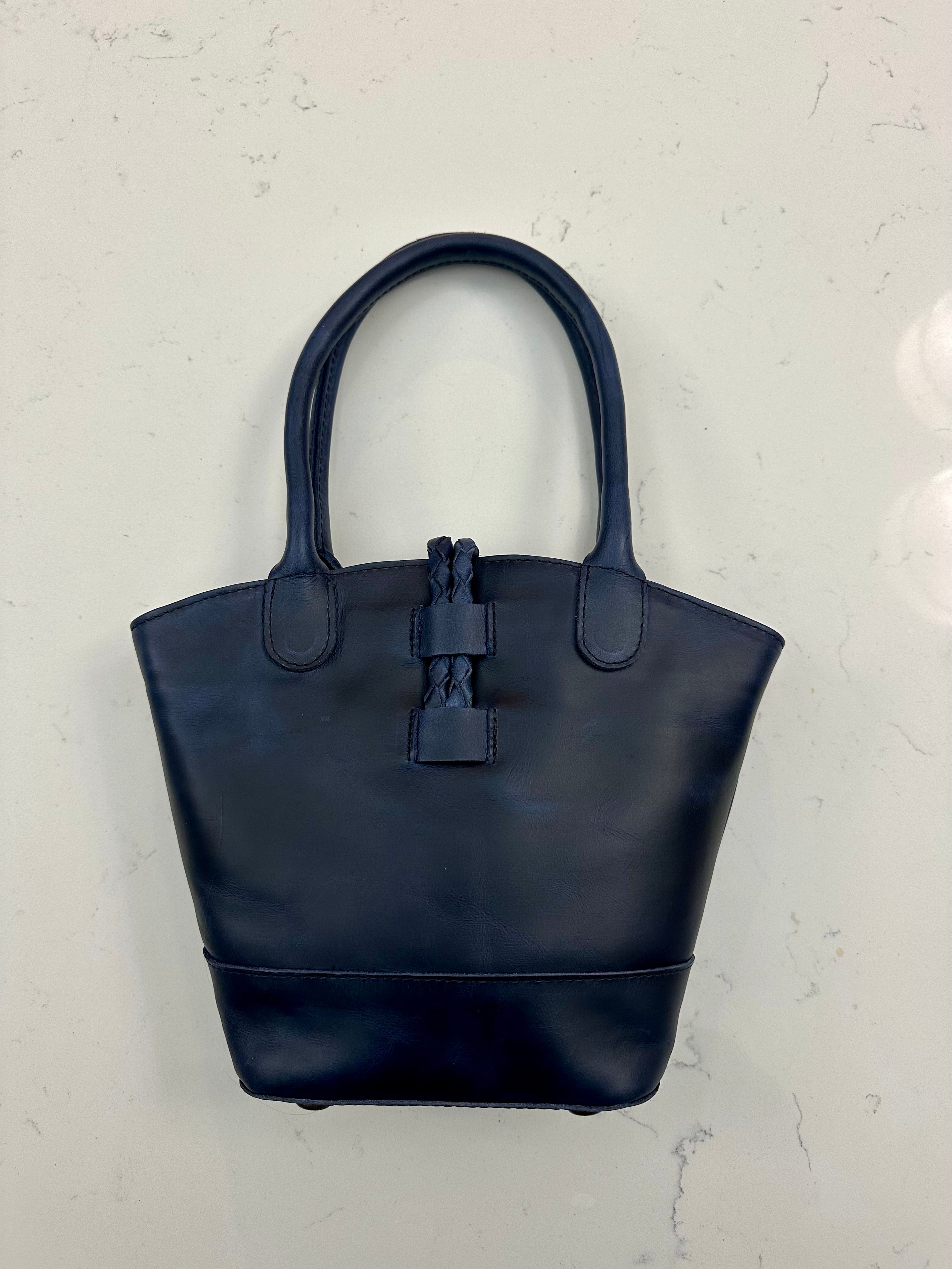 Navy blue handbag on a light gray background