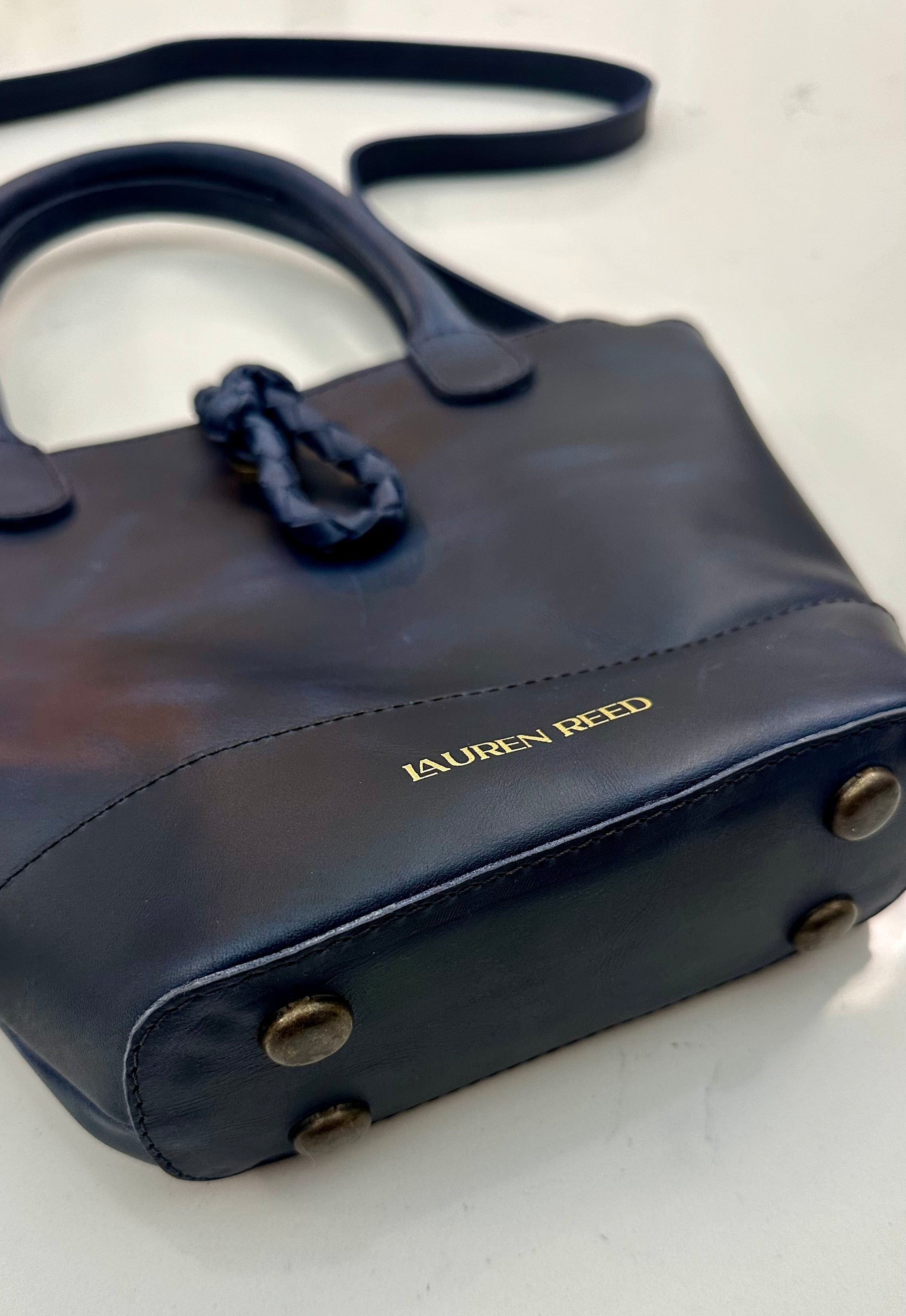 Blue handbag with gold foil detail on a white background