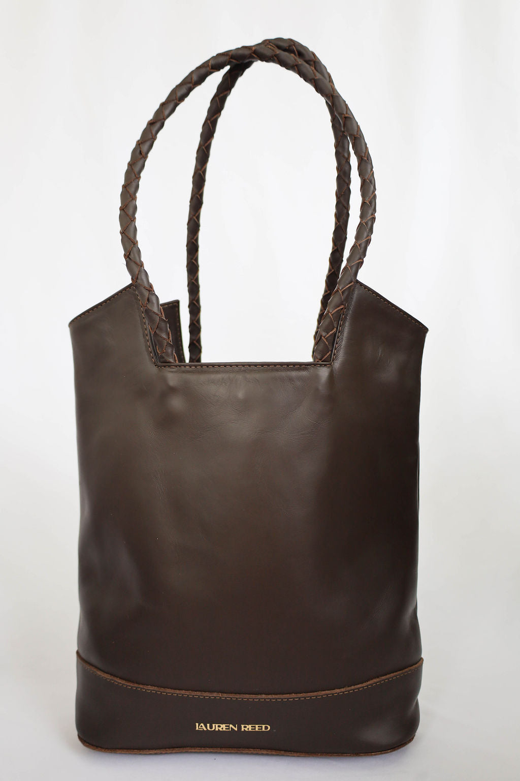 Brown leather tote bag with rope handles on a white background