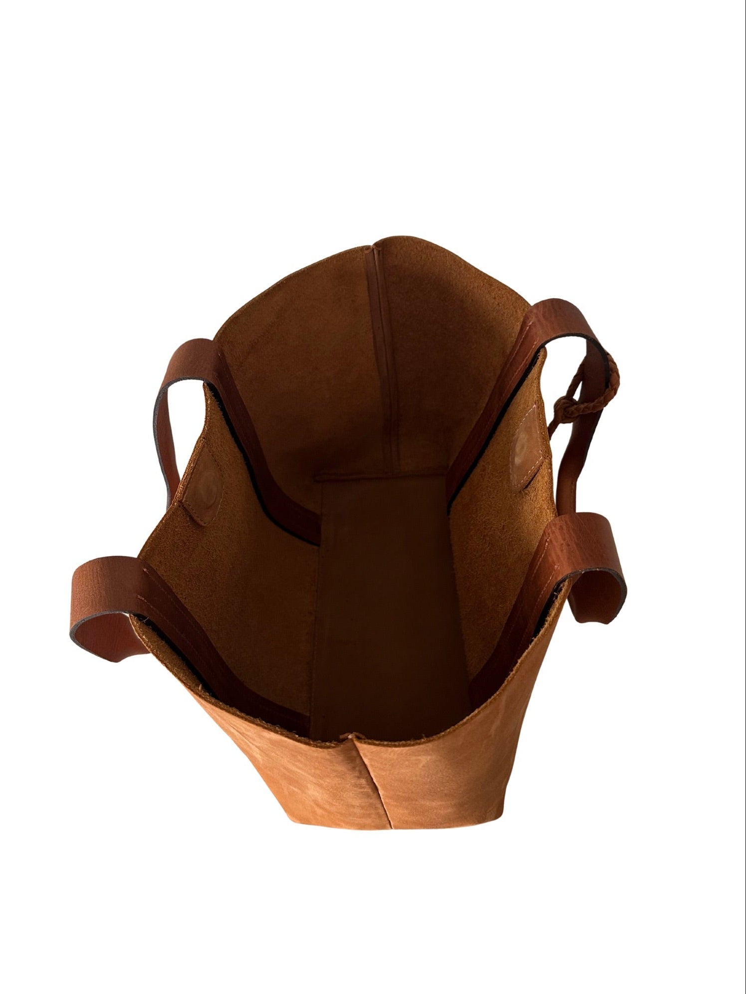 Inside of unlined full grain tan leather bag on a white background.