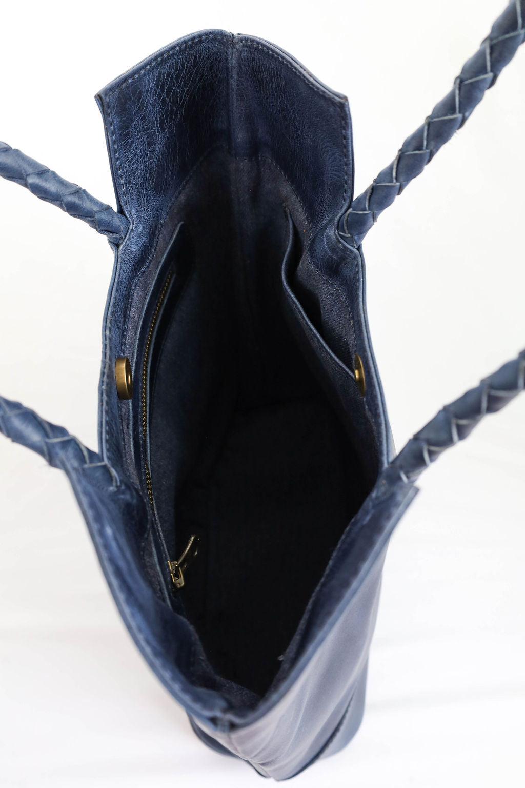 Blue handbag with braided handles on a white background
