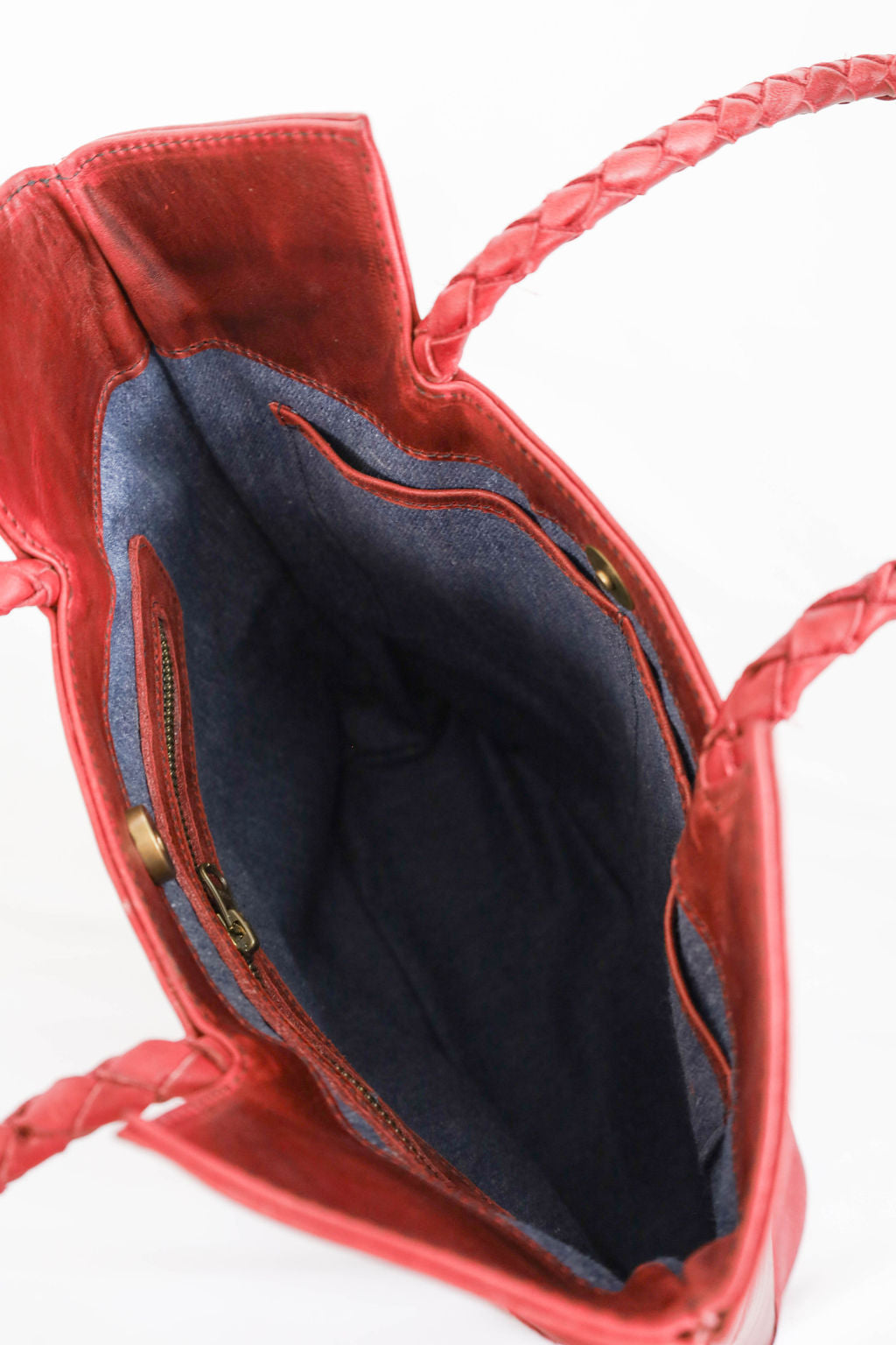 Red handbag with denim interior on a white background
