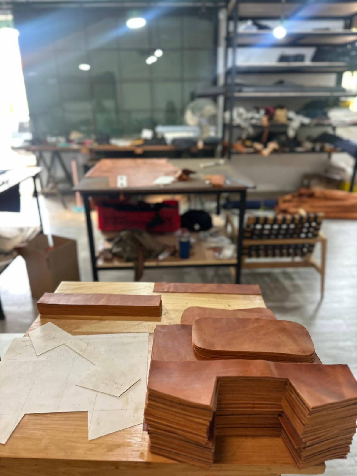Stacks of leather on a table with a workshop background