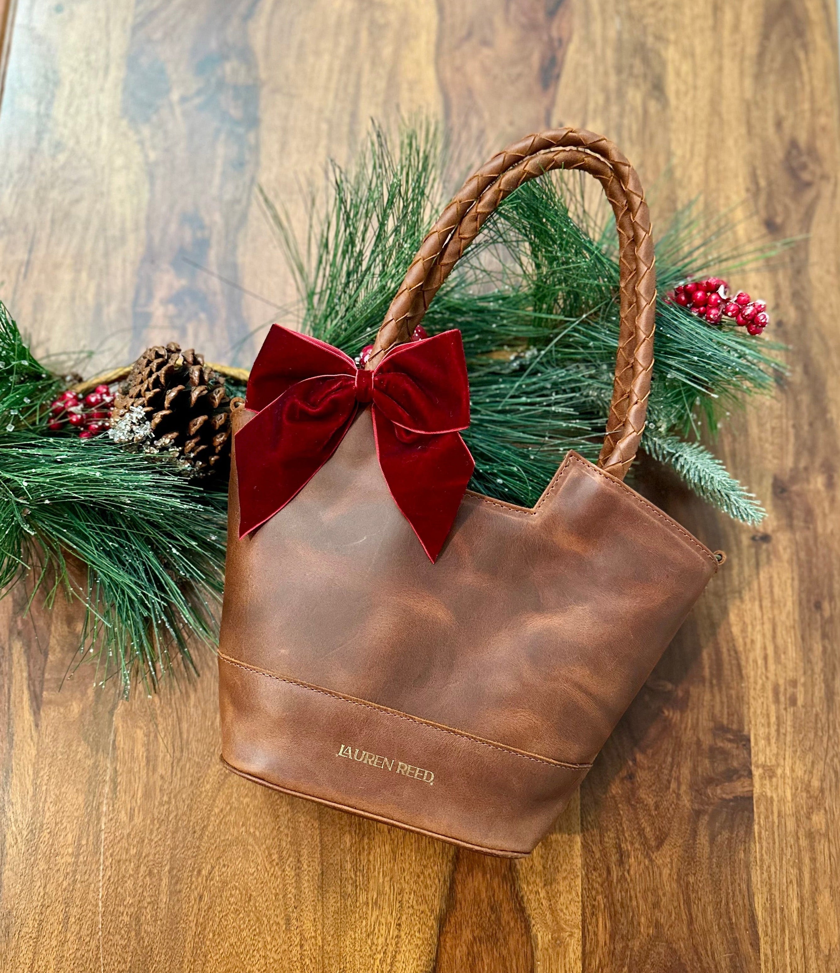 Leather Bag with Christmas Bow and greenery.