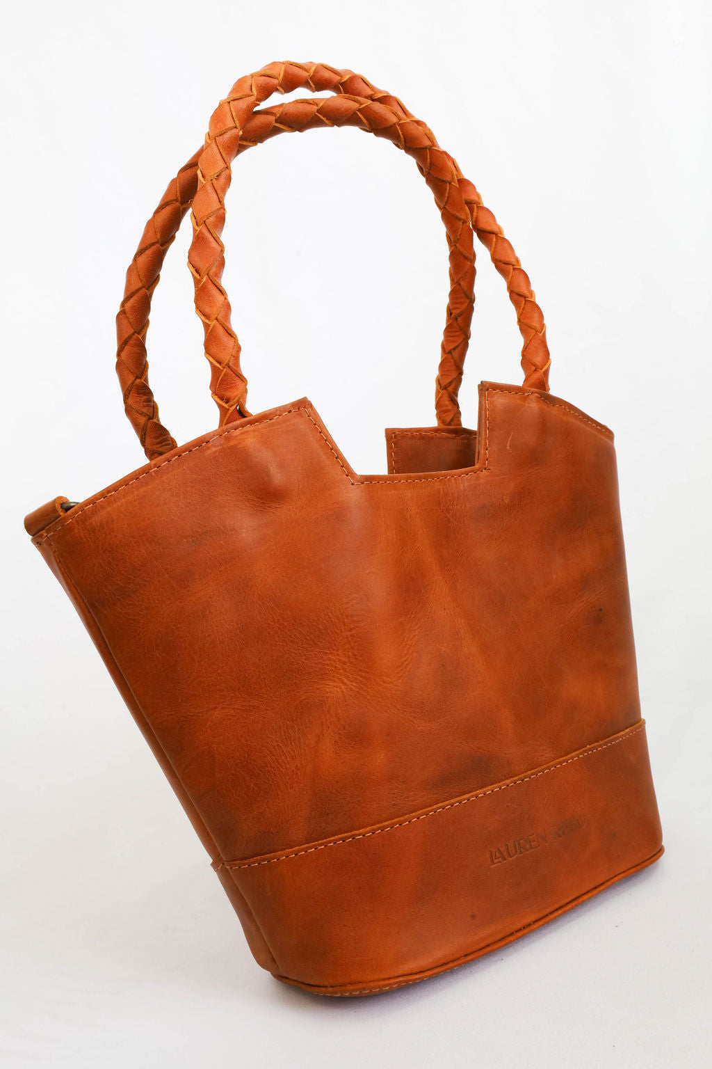 leather bag with braided handles on a white background