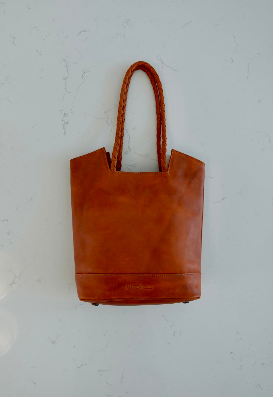 Rustic tan leather tote bag on marble