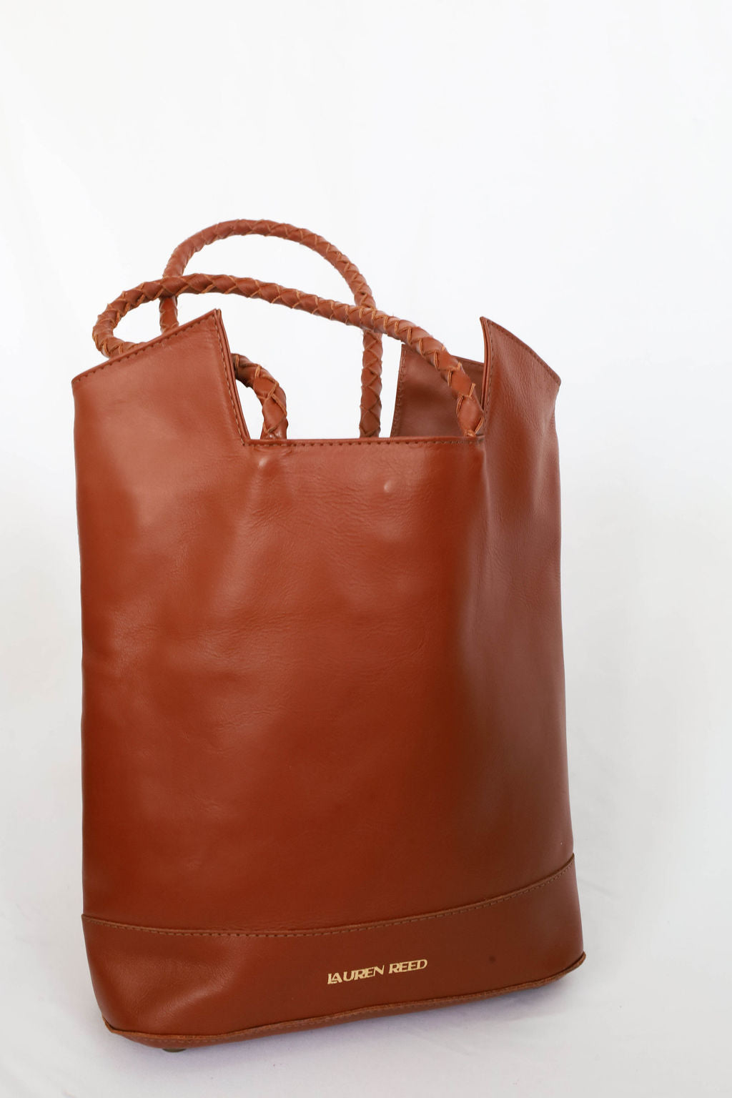 Brown leather bag with rope handles on a white background