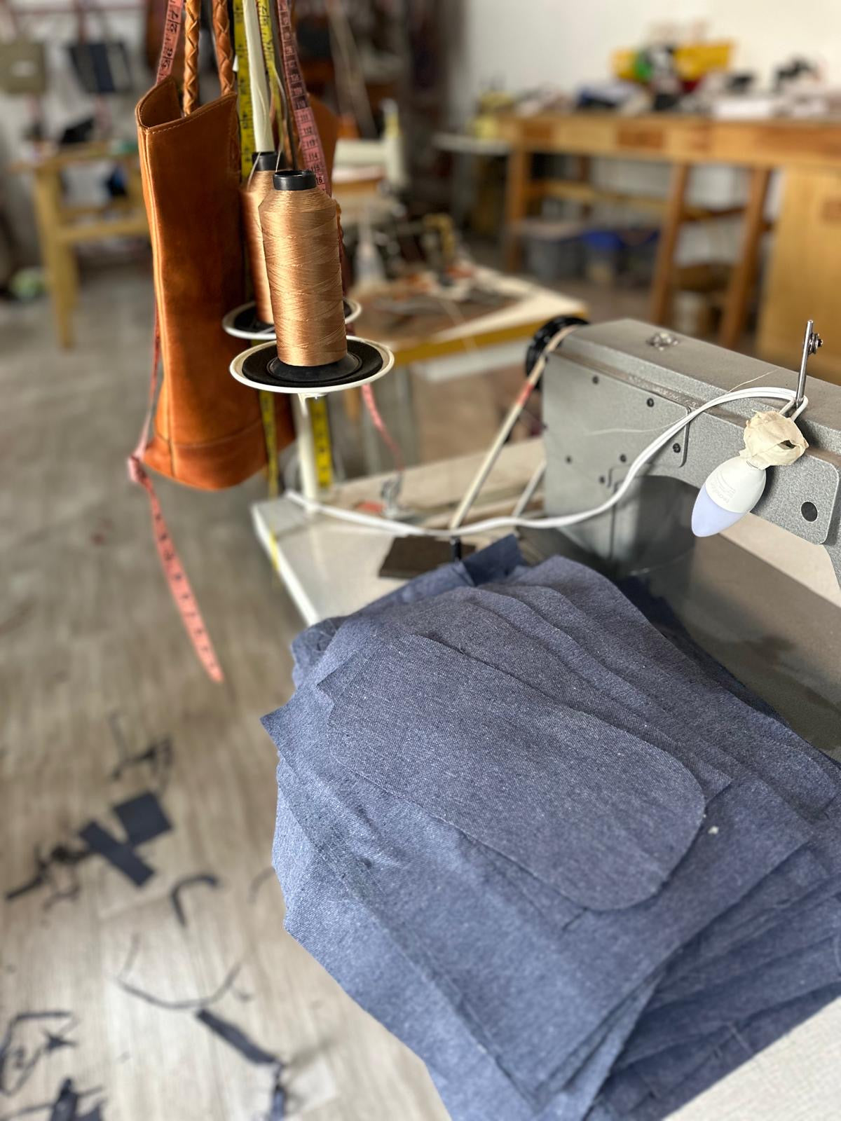 Spools of thread and sewing machine in a workshop setting
