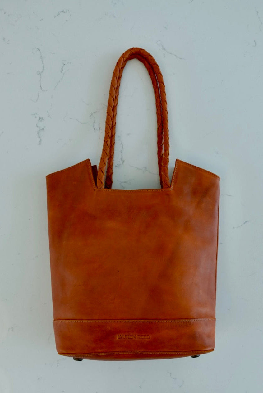 Rustic tan leather purse tote bag on marble 