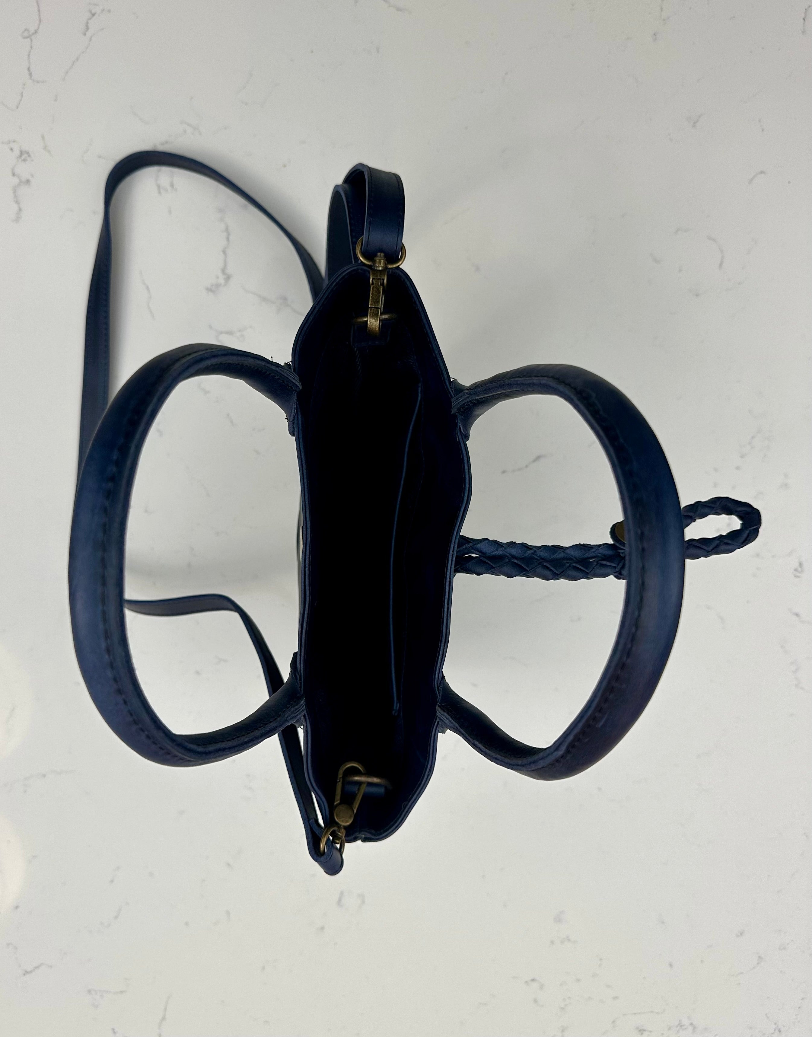 Blue leather bag with a strap on a light background