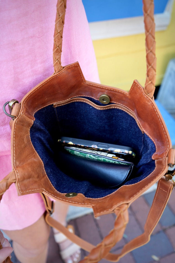 Tan leather handbag with upcycled sustainable blue denim interior.