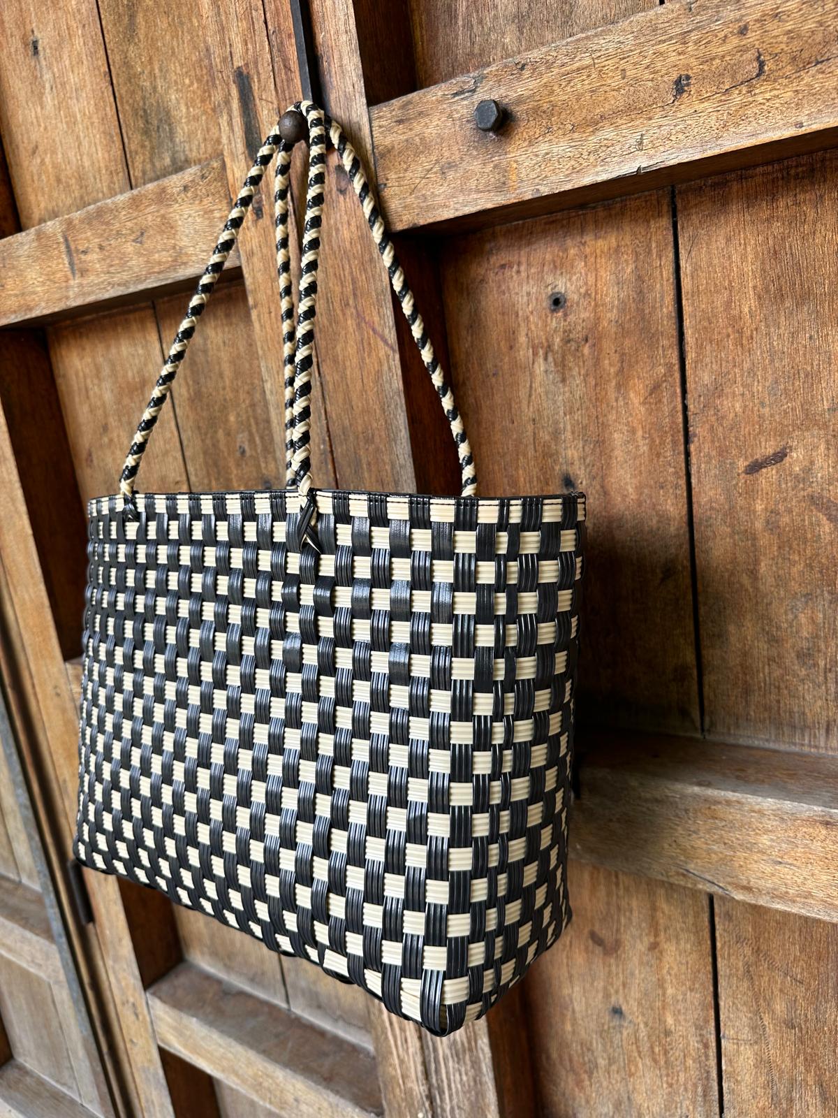 Close up of handwoven upcycled plastic tote bag in black and cream made by Guatemalan artisans