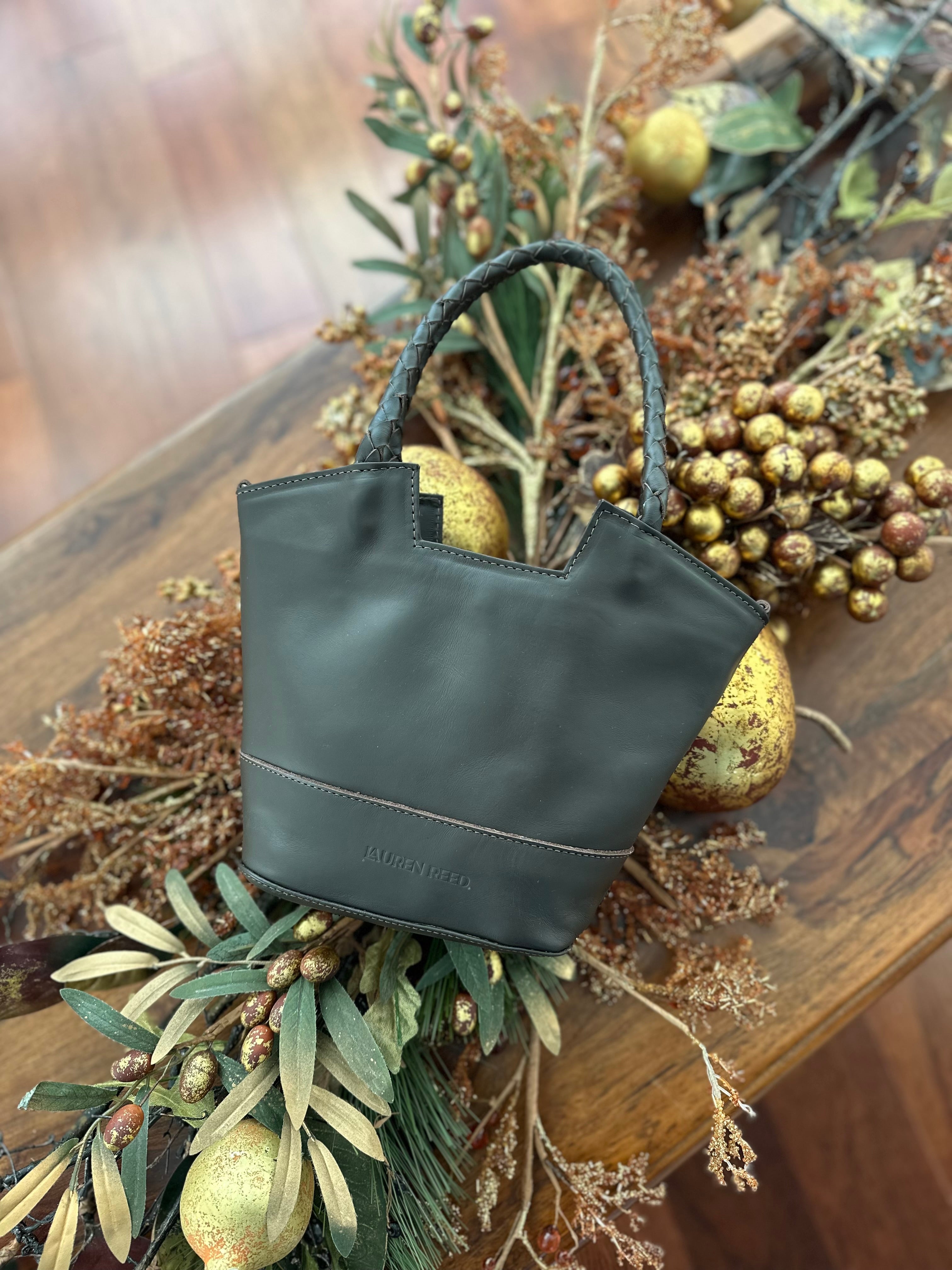 Dark brown leather handbag on a wooden surface with decorative holiday elements
