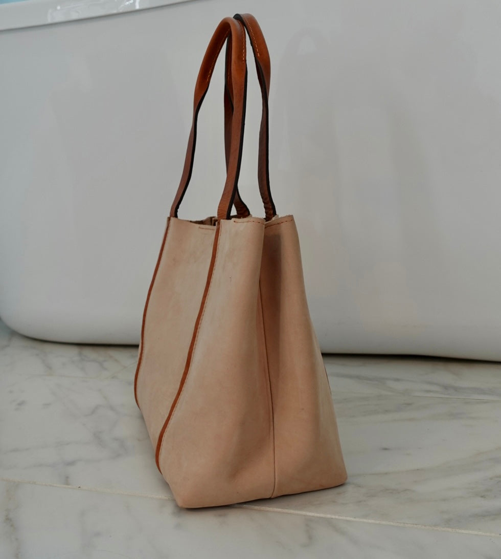 Beige tote bag with brown accents on a marble surface