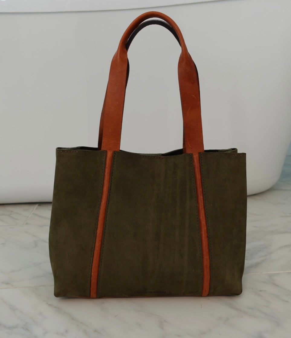 Green tote bag with tan accents on a marble surface