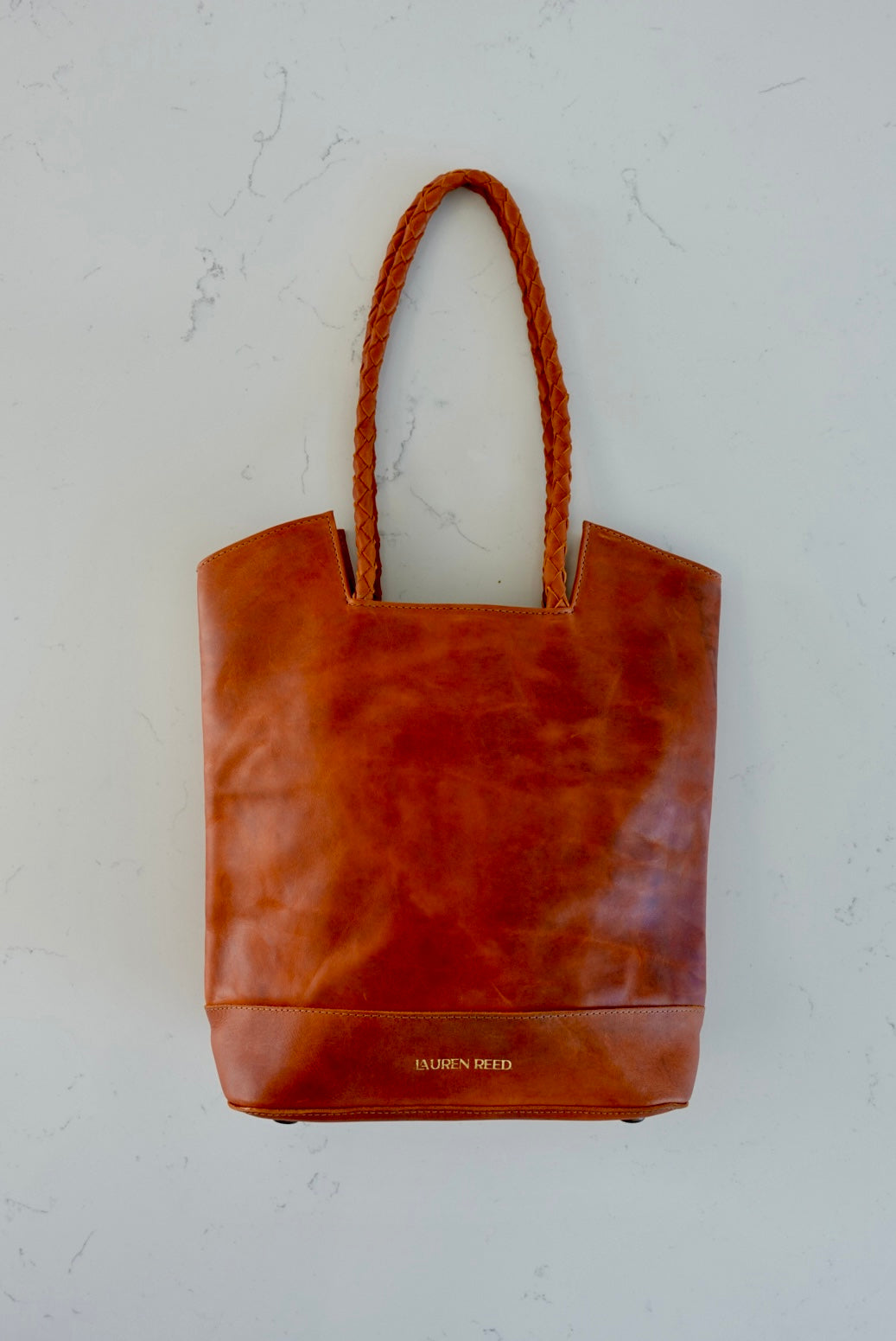 Rustic tan leather tote bag on marble 