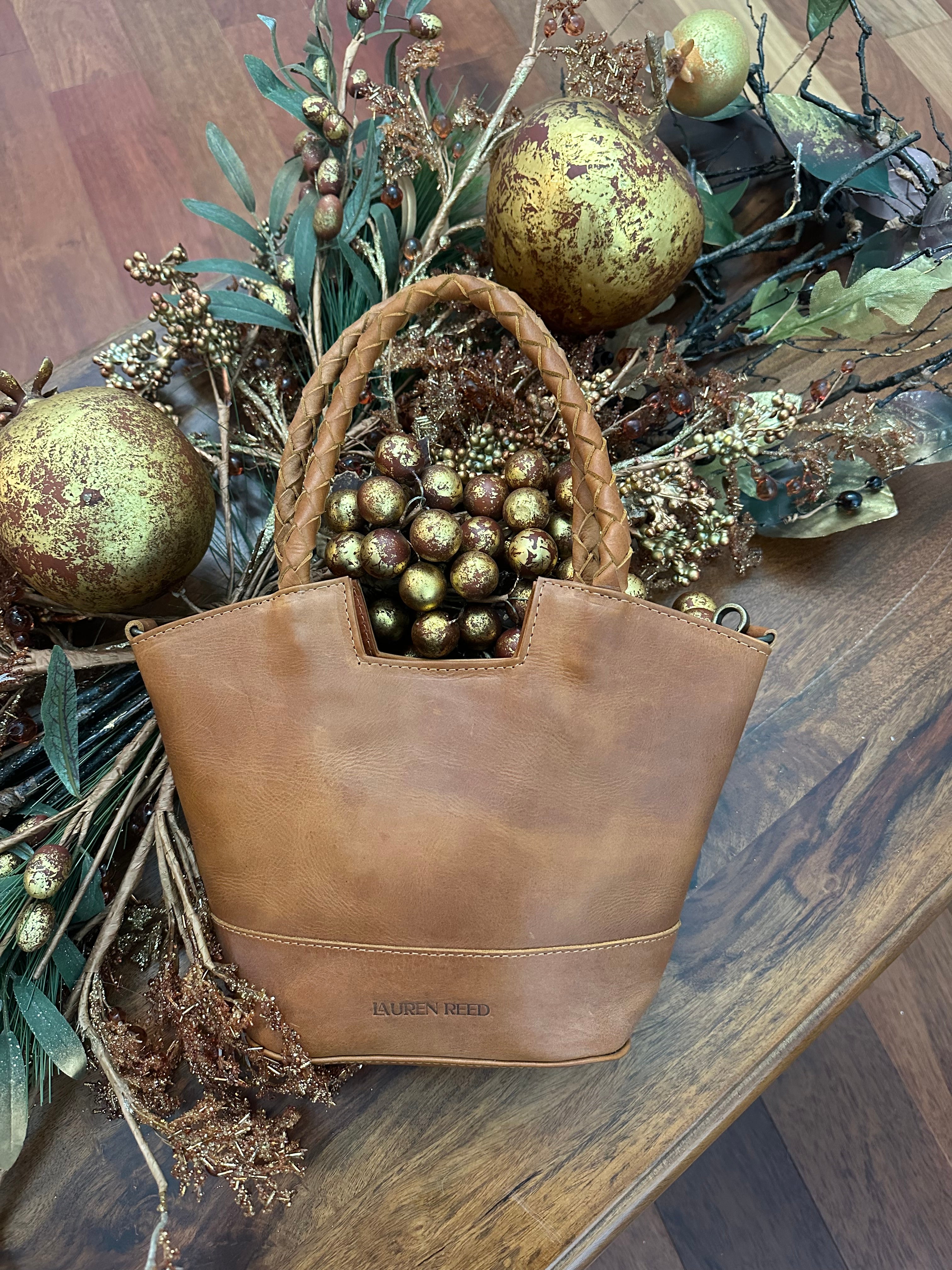 Brown leather bag with decorative elements on a wooden surface